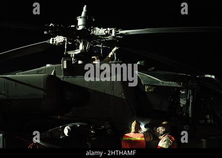 Zwei Soldaten der US-Armee, die dem 1-3.-Angriffsbataillon, der 12. Combat Aviation Brigade, zugewiesen wurden, bereiten sich auf den Treibstoff der Apache Longbow-Hubschrauber AH-64D auf dem Lielvarde Military Airfield, Lettland, 24. Februar 2022 vor. Elemente des CAB 12 verließen Deutschland nach Litauen und Lettland, um mit NATO-Verbündeten zur Unterstützung von Sabre Strike 22 zu trainieren. 12 CAB trainiert und bleibt eine ständige und glaubwürdige Luftwaffe der US-Armee zur Unterstützung von Verbündeten und Partnern sowie der Stabilität und Sicherheit Europas. (USA Foto der Armee von Staff Sgt. Thomas Mort) Stockfoto