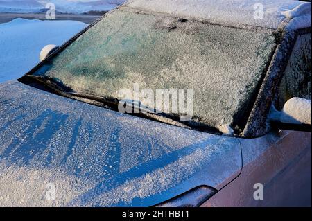 Die Windschutzscheibe war an einem sonnigen Wintertag mit Frost bedeckt Stockfoto