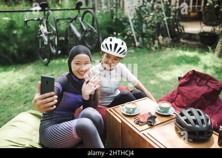 Schöne Radfahrer machen eine Pause im Café und machen Fotos zusammen Stockfoto