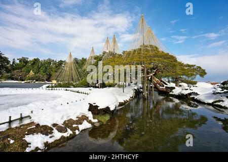 Ishikawa, Japan - 25. Februar 2022: Steinlaterne entlang des gefrorenen Kasumigaike-Teiches in Kenrokuen, einem der schönsten Gärten Japans, im Winter Mo Stockfoto