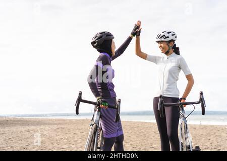 asian zwei Radfahrer Freund hoch fünf, wenn ihr Rennen zu beenden Stockfoto