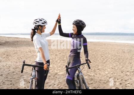 asian zwei Radfahrer Freund hoch fünf, wenn ihr Rennen zu beenden Stockfoto