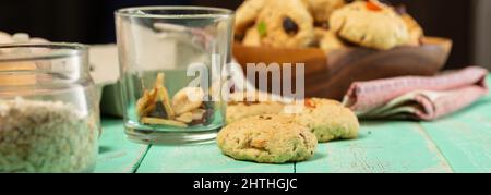 Kochen Haferflockenkekse mit kandierten Früchten und Walnüssen. Eier, Haferflocken, Mehl, Zucker, Gewürze und Küchenutensilien auf einem alten Holz Stockfoto