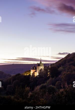 Luftaufnahme der Castell Coch in Cardiff, Wales unter grünen Bergen mit einem Sonnenuntergang wolkigen Himmel Stockfoto