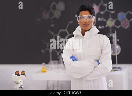 Ein selbstbewusster Forscher. Ein Porträt einer schönen jungen Wissenschaftlerin, die stolz in ihrem Labor steht. Stockfoto