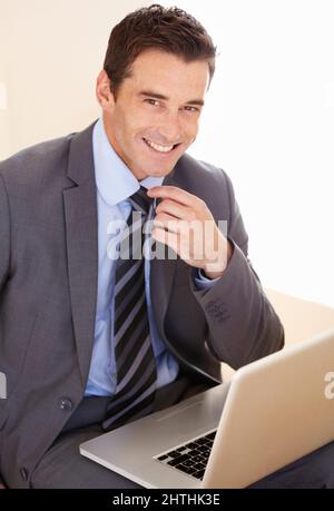 Hes ein versierter Geschäftsmann. Porträt eines hübschen jungen Geschäftsmannes, der seinen Laptop benutzt. Stockfoto