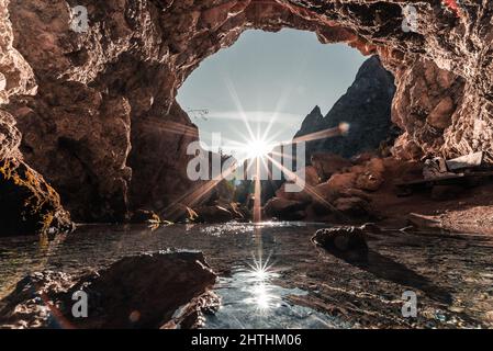 Wunderschöne Aufnahme einer prallen Sonne, die durch ein Loch in der Höhle gesehen wird Stockfoto