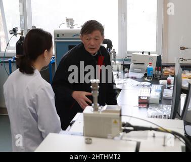 (220301) -- DUNHUANG, 1. März 2022 (Xinhua) -- Su Bomin (R) spricht mit einem Techniker an der Dunhuang Akademie in Dunhuang, nordwestlich von Gansu, Provinz Chinas, 23. Februar 2022. Su Bomin, Abgeordneter des Nationalen Volkskongresses (NPC), ebenfalls Dekan der Dunhuang Academy, arbeitet seit drei Jahrzehnten in den Mogao-Grotten, einem UNESCO-Weltkulturerbe in Dunhuang, nordwestlich der chinesischen Provinz Gansu. Su hat seit Beginn seines Dienstes als NPC-Stellvertreter eine Reihe von Vorschlägen zum Schutz kultureller Reliquien unterbreitet. Während der diesjährigen „zwei Sitzungen“, der jährlichen Sitzungen des National People“ Stockfoto