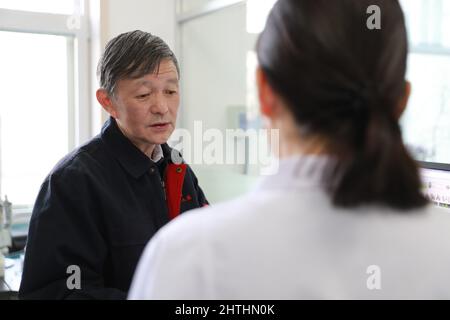 (220301) -- DUNHUANG, 1. März 2022 (Xinhua) -- Su Bomin (L) spricht mit einem Techniker der Dunhuang Akademie in Dunhuang, nordwestlich von Gansu, Provinz Chinas, am 23. Februar 2022. Su Bomin, Abgeordneter des Nationalen Volkskongresses (NPC), ebenfalls Dekan der Dunhuang Academy, arbeitet seit drei Jahrzehnten in den Mogao-Grotten, einem UNESCO-Weltkulturerbe in Dunhuang, nordwestlich der chinesischen Provinz Gansu. Su hat seit Beginn seines Dienstes als NPC-Stellvertreter eine Reihe von Vorschlägen zum Schutz kultureller Reliquien unterbreitet. Während der diesjährigen „zwei Sitzungen“, der jährlichen Sitzungen des National People“ Stockfoto