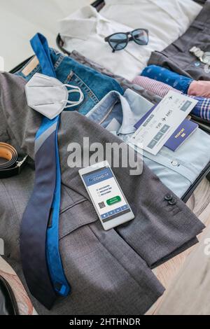 Businessman Koffer Vorbereitungen für Geschäftsreise mit covid Pass Stockfoto