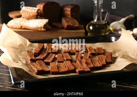 Backblech mit leckeren Roggencroutons auf dem Tisch Stockfoto