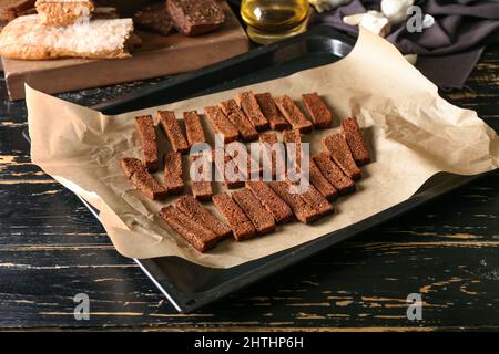 Backblech mit leckeren Roggencroutons auf dem Tisch Stockfoto