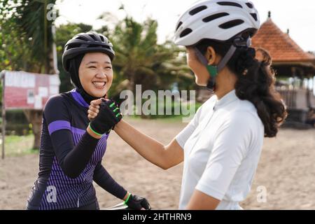 asian zwei Radfahrer Freund hoch fünf, wenn ihr Rennen zu beenden Stockfoto