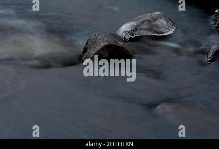 Wasser läuft frei über Steine in Stromschnellen Stockfoto