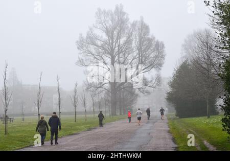 Brighton UK 1. March 2022 - Läufer und Wanderer im Preston Park Brighton an einem nebligen ersten Frühlingstag durch den meteorologischen Kalender, der am 1.. März beginnt : Credit Simon Dack / Alamy Live News Stockfoto