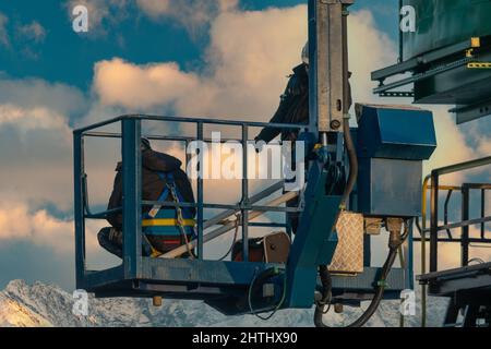 Montagearbeiter reparieren einen Hafenkran auf einem Hochhub Stockfoto