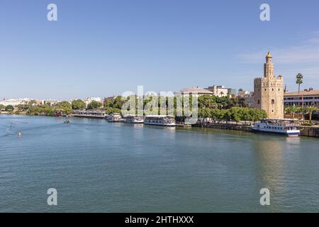 Editorial: SEVILLA, ANDALUSIEN, SPANIEN, 10. OKTOBER 2021 - ein Arm des Guadalquivir, der mit dem Goldenen Turm durch die Innenstadt Sevillas läuft Stockfoto