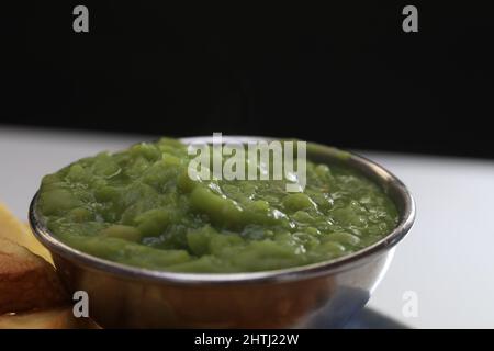 Mushy Peas im Compo's Fish and Chip Restaurant und Take Away, Holmfirth, West Yorkshire. Stockfoto