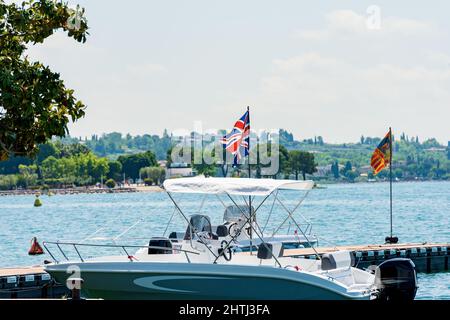 Zwei kleine Schnellboote, die an der Küste des Gardasees vor dem Dorf Bardolino, Ferienort in der Provinz Verona, Venetien, Italien, Europa, festgemacht sind. Stockfoto