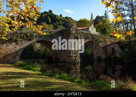 Romanische Steinbrücke und Kirche Santa María de Vilanova im schönen Dorf Allariz im Herbst, Orense, G Stockfoto