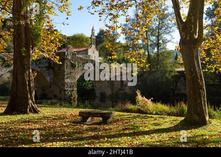 Romanische Steinbrücke und Kirche Santa María de Vilanova im schönen Dorf Allariz im Herbst, Orense, G Stockfoto