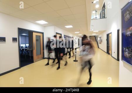 Kinder, die zwischen Klassenzimmern, Schulfluren und Treppen laufen. Langsame Belichtung, um Identität zu verbergen Stockfoto