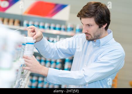 Mann Auswahl Farbe Farbe bei Hardware Store Stockfoto