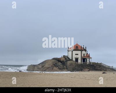 Schöne Aufnahme der katholischen Kirche Capela do Senhor da Pedra gegen ein welliges Wasser Stockfoto