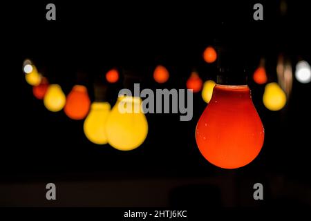 Ein Festtag mit roten und gelben Glühbirnen, die während einer Party leuchten, um festliche Stimmung zu schaffen Stockfoto