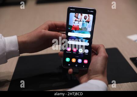 Barcelona, Spanien. 28.. Februar 2022. Ein Besucher schaut sich das Smartphone Samsung Galaxy Z Flip3 5G auf dem Stand von Samsung während des Mobile World Congress (MWC) an, der jährlichen Messe, die von GSMA auf der Fira de Barcelona, Spanien, organisiert wird. Stockfoto