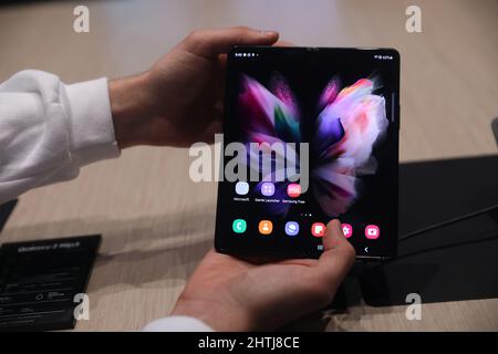 Barcelona, Spanien. 28.. Februar 2022. Ein Besucher schaut sich das Smartphone Samsung Galaxy Z Fold3 5G auf dem Stand von Samsung während des Mobile World Congress (MWC) an, der jährlichen Messe, die von GSMA auf der Fira de Barcelona, Spanien, organisiert wird. Stockfoto