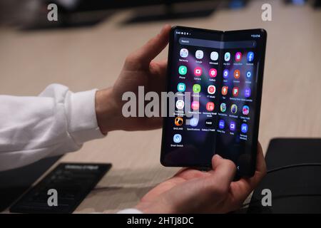 Barcelona, Spanien. 28.. Februar 2022. Ein Besucher schaut sich das Smartphone Samsung Galaxy Z Fold3 5G auf dem Stand von Samsung während des Mobile World Congress (MWC) an, der jährlichen Messe, die von GSMA auf der Fira de Barcelona, Spanien, organisiert wird. Stockfoto