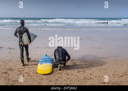 Surfer bereiten sich auf eine Surfstunde am Fistral Beach in Newquay in Cornwall in Großbritannien vor. Stockfoto