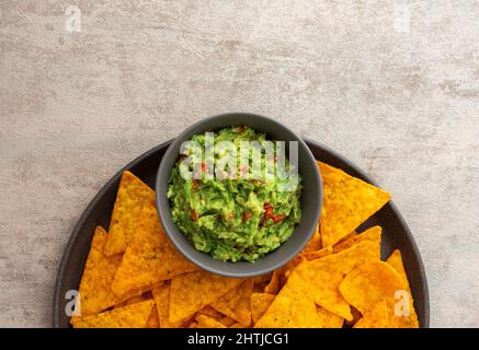 Mexikanische Maischips Nachos mit Avocado-Paprikasoße, Draufsicht, Kopierraum Stockfoto