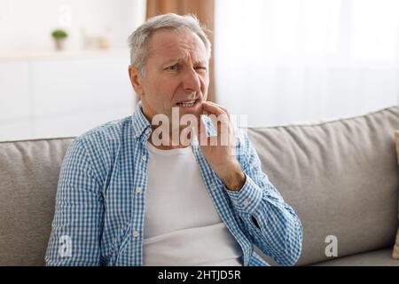 Porträt eines unglücklichen, reifen Mannes, der an Zahnschmerzen leidet Stockfoto