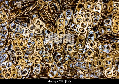 Von oben Full Frame Stapel aus goldenem Aluminium Ring zieht aus Metalldosen zusammen für die Handarbeit in hellen Raum gestapelt Stockfoto