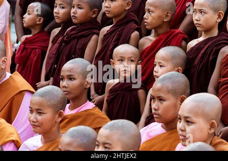 Yangon, Myanmar - 04.19.2017: Gruppe asiatischer Novizenmönche in Soutane in Reihen der buddhistischen Shwedagon-Pagode Stockfoto