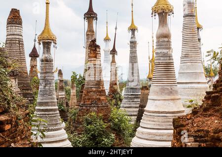 Reihen mit Fülle von alten Kakku Pagoden, die sich an der Straße von Taunggyi gegen den wolkenlosen Himmel in Myanmar am Sommertag befinden Stockfoto