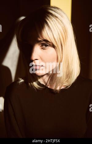 Crop anonyme Arbeiter mit speziellen tragbaren Kettensäge Sägen dünnen Baumstamm mit Ästen während der Arbeit in der Natur am Sommertag Stockfoto