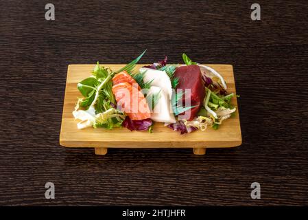 Dieses Tablett mit Sashimi oder Scheiben rohen Fischs ist eine der Köstlichkeiten, die uns die japanische Küche bringt. Brassen, Lachs, Thunfisch, Wasabi und Sojasauce. Stockfoto