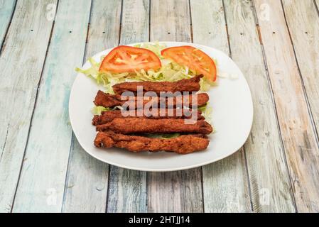 Seekh Kebab wird mit gewürztem, gehacktem oder gemahlenem Fleisch, in der Regel Lamm, Rind oder Huhn, auf Spieße gerollt und gegrillt, hergestellt. Es wird in der Regel in einer mang gekocht Stockfoto