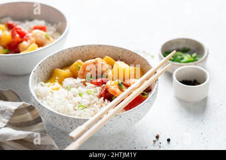 Ananasgarnelen in süß-saurer Sauce mit weißem Reis in einer Schüssel. Thailändische Küche. Nahaufnahme, Platz kopieren Stockfoto