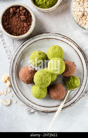 Süße vegane Trüffel mit grünem Matcha-Teepulver, Nüssen, Hafer und Datteln. Draufsicht. Gesunde kalorienarme hausgemachte Süßigkeiten Stockfoto