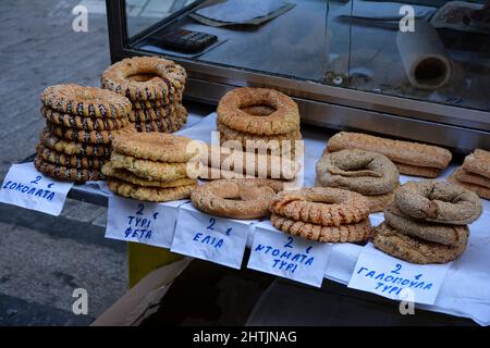 Cookies auf einem Tablett in Griechenland. Namen von Cookies auf Griechisch und Preise auf Papier geschrieben. Selektiver Fokus auf Front-Cookies Stockfoto