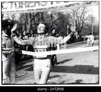Die Eliteläuferin Kathy McIntyre überquert die Ziellinie als Siegerin bei einem Rennen 10K in Prospect Park, Brooklyn, New York. Ca. 1980 Stockfoto
