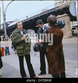 Fritz Pleistgen, deutscher Journalist, ARD Korrespondent in Ost-Berlin, hier mit einem Kamerateam, 1981. Fritz Pleistgen, deutscher Journalist, ARD-TV-Korrespondent in Ost-Berlin, hier mit Kamerateam, 1981. Stockfoto