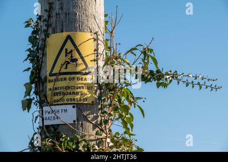 Warnschild „Todesgefahr“ an einem Holzmast angebracht Stockfoto