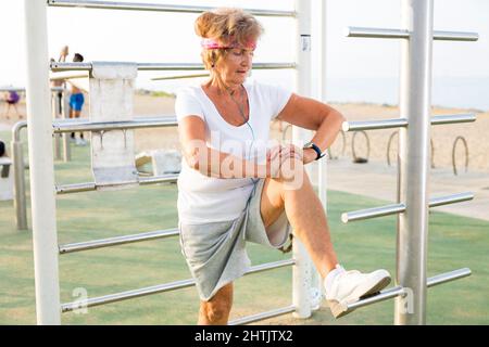 Alte Frau macht Fitness-Übungen im Freien Stockfoto