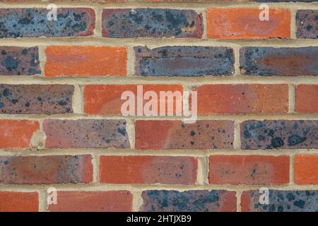 Nahaufnahme eines Teils einer gemischten roten Ziegelwand, Trage-Bond-Format Stockfoto