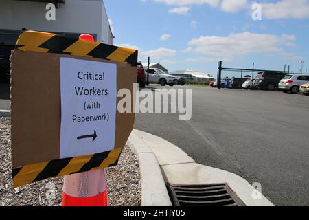 Christchurch, Neuseeland. 28.. Februar 2022. Ein Schild weist kritische Arbeiter darauf hin, dass sie für Tests schnell nachverfolgt werden.eine große Zahl von Menschen, die in Christchurch getestet werden wollen, stehen an einem Testgelände in der Nähe des Flughafens in einer Warteschlange von mehr als 2,5 km, was einer Wartezeit von rund zwei Stunden entspricht. Die Fälle liegen bei etwa 15.000 pro Tag, wobei die Fälle in der nächsten Woche um das Doppelte getippt werden. Kredit: SOPA Images Limited/Alamy Live Nachrichten Gutschrift: SOPA Images Limited/Alamy Live Nachrichten Stockfoto